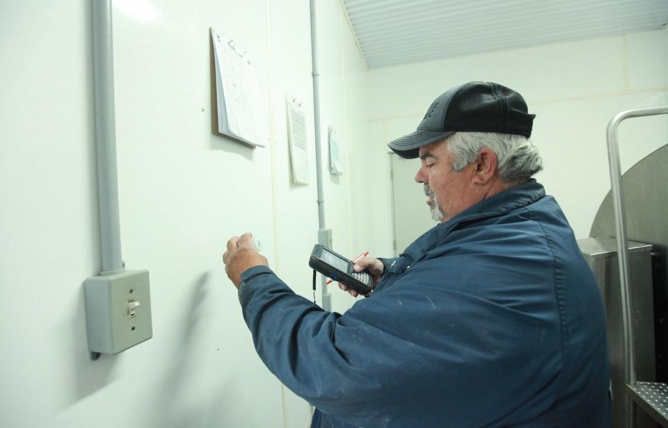 Un conducteur de camion de lait et classeur qualifié, prélève des échantillons de lait.