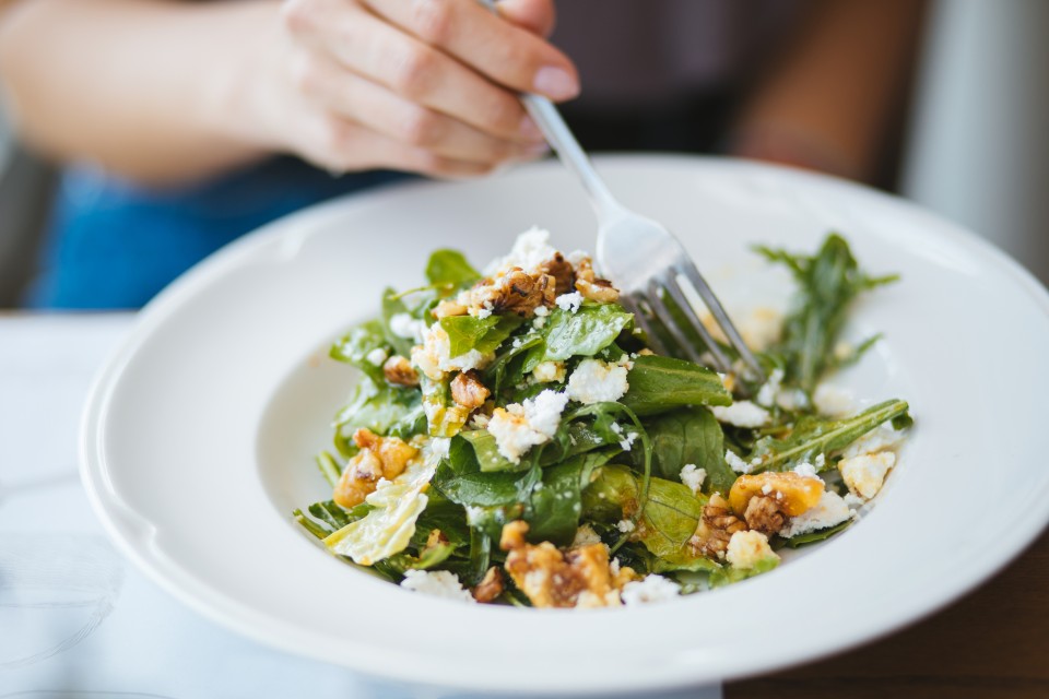 Une salade verte avec du fromage et des noix